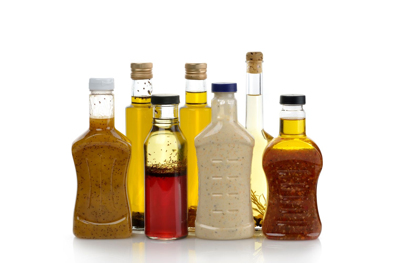 Salatsaucen Verschiedene Flaschen mit Salatdressings vor weißem Hintergrund, darunter Öl- und Essigsorten.